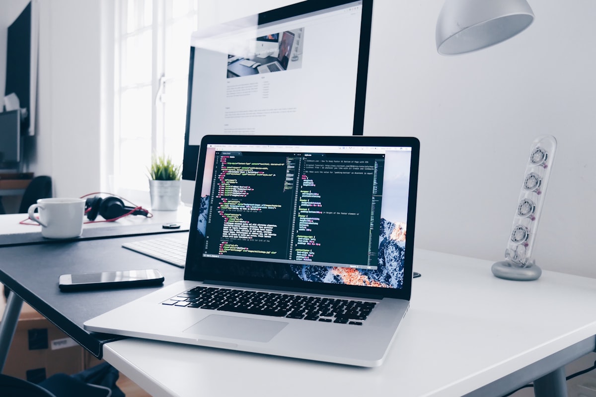 A clean desk with a laptop displaying code